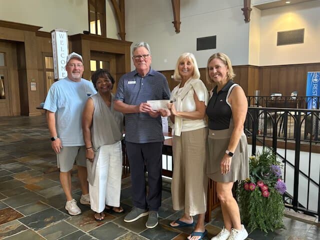 Supporters presenting a donation check to Our Father's Kitchen
